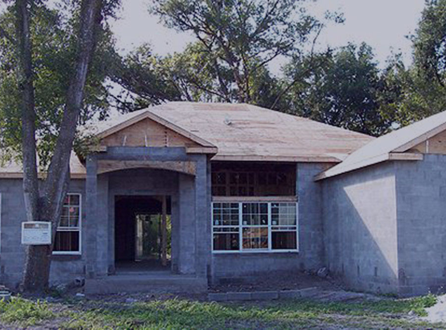 Home under construction with plywood roof decking and concrete block walls