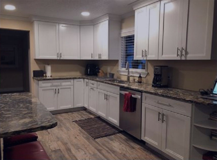 Remodeled kitchen with white cabinets and granite countertops